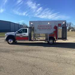 Photo of Roscoe Fire Department ambulance vehicle being showcased outside with open hardware cabinets.
