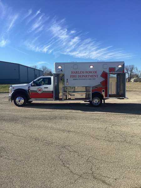 Photo of Roscoe Fire Department ambulance vehicle being showcased outside with open hardware cabinets.